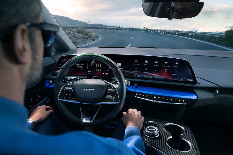 Front View of the 2026 OPTIQ-V Driving Through the Dusk Utilizing its Headlights | Cadillac of Rexburg in Rexburg ID